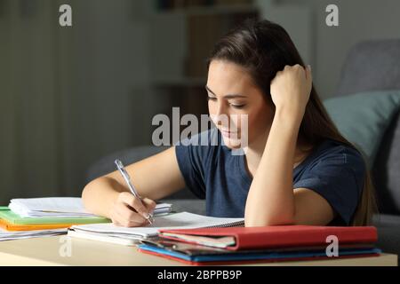 L'apprentissage des élèves qui travaillent fort studieux en prenant des notes dans la nuit à la maison Banque D'Images