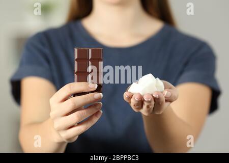 Vue avant close up of a woman mains montrant le sucre et le chocolat assis sur un canapé dans la salle de séjour à la maison Banque D'Images