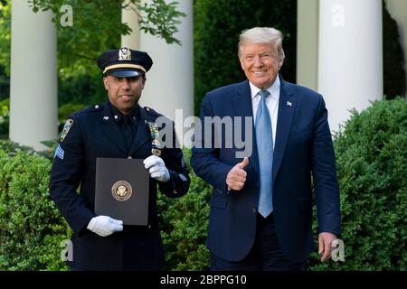 Le président américain Donald Trump présente à l'agent de police de New York Spencer Garrett un certificat de reconnaissance lors de la cérémonie de reconnaissance présidentielle : Travail acharné, héroïsme et espoir dans le jardin des roses de la Maison Blanche le 15 mai 2020 à Washington, D.C., l'événement a honoré les travailleurs de première ligne luttant contre la pandémie de coronavirus COVID-19. Banque D'Images