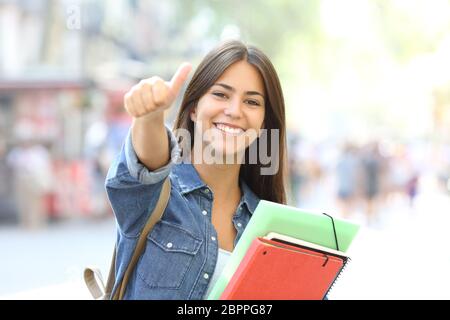 Happy student posing with Thumbs up vous regarde dans la rue Banque D'Images