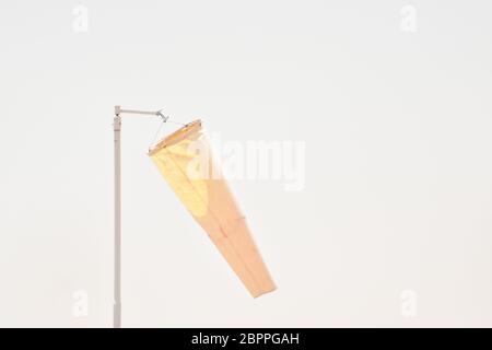 Chaussette de vent orange contre le ciel bleu. Chaussette de vent de l'équipement vérifier la direction du souffle de vent dans la journée et aucun souffle de vent sur ciel couvert nuageux. Banque D'Images