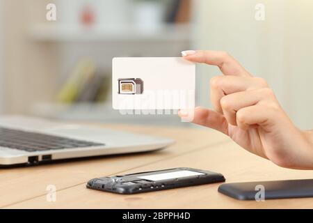 Close up of a woman holding a blank nouvelle carte SIM à la maison Banque D'Images