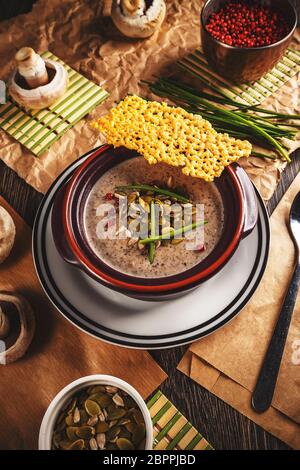 Bol de soupe crème de champignon délicieux servi avec des graines de potiron et fromage croquant Banque D'Images