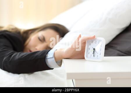 Two businesswomen sur le lit se réveiller après une nuit blanche habillée Banque D'Images