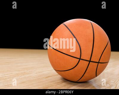 Basket Ball avec plancher en bois isolé sur noir avec copy-space Banque D'Images