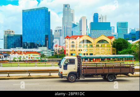 Chariot sur une route passant par le centre-ville de Singapour ville avec des gratte-ciel de l'architecture moderne Banque D'Images