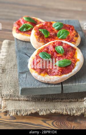 Mini pizzas Margherita avec fromage rouge sur la planche de bois Banque D'Images