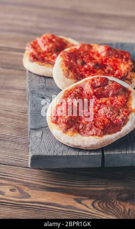 Mini pizzas Margherita avec fromage rouge sur la planche de bois Banque D'Images