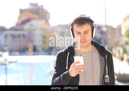 Fronf voir portrait d'un ado sérieux à écouter de la musique dans la rue d'une ville côtière Banque D'Images