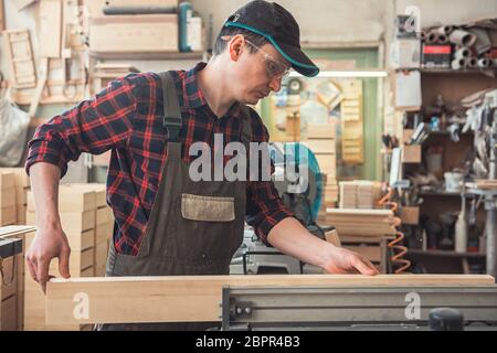 Chef de bloc de bois rabotés avec machine électrique Banque D'Images