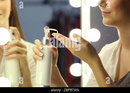 Portrait of a woman applying moisturizer cream sur les mains en face d'un miroir de maquillage Banque D'Images