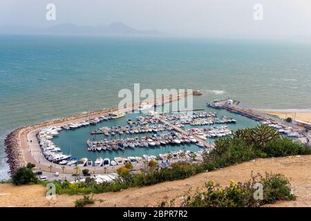 Vue sur la côte méditerranéenne avec des bateaux dans le port de Sidi Bou Said, Tunisie Banque D'Images