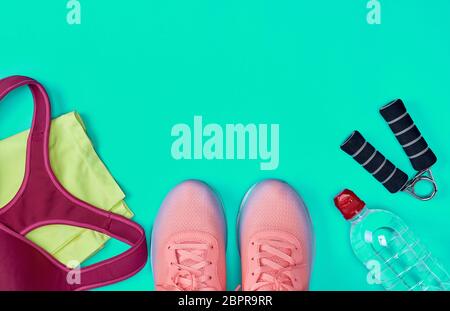 Chaussures de sport et autres articles textiles pour la remise en forme sur un fond vert, vue du dessus, copy space Banque D'Images