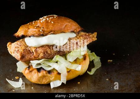 gros plan sur un hamburger de poulet doré rustique Banque D'Images