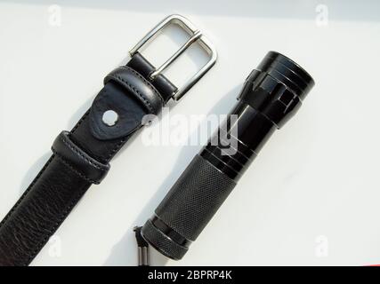 Accessoires pour hommes bracelet en cuir noir et lampe isolé sur fond blanc. Banque D'Images