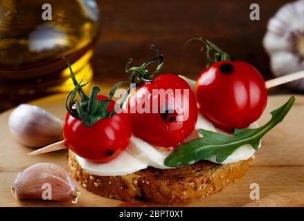 Bruschetta à la mozzarella, tomates cuites au four et arugula Banque D'Images