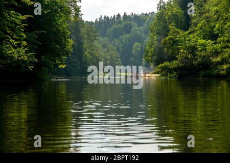 Les gens de bateau sur river en Lettonie Gauja, endroit calme nature scène. En radeau à travers la rivière. Projet de voyage le long de la rivière Gauja en Lettonie. L'Ancien hôtel est e Banque D'Images