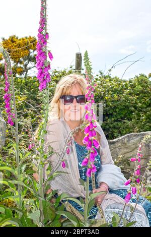 Belle femme d'âge moyen entre les gants fox sauvages dans la campagne irlandaise Banque D'Images
