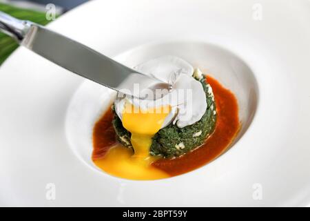 Martinelle compochée avec beurre, fromage et œuf poché servi dans une assiette blanche. Banque D'Images