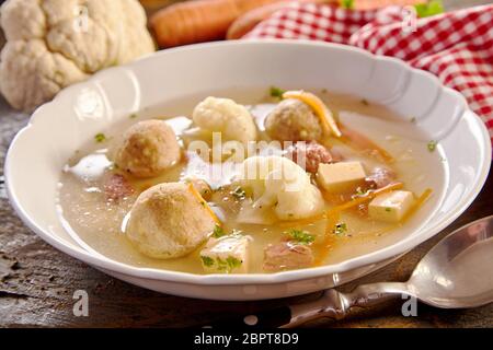 Soupe de printemps spécialiste allemand avec des boulettes de moelle dans un bouillon avec les carottes, chou-fleur et fromage aux herbes fraîches Banque D'Images