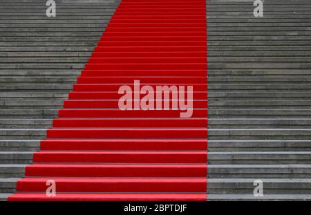 Gros plan sur le tapis rouge des escaliers de béton gris, ascendant perspective low angle view Banque D'Images