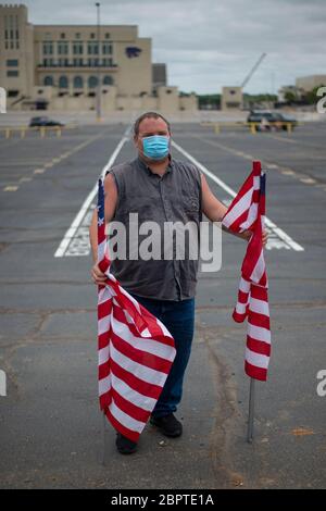 Manhattan, Kansas, États-Unis. 19 mai 2020. Le membre de l'American Legion Post 17, BRAD SCHULTZ, détient mardi des drapeaux américains en face de l'Ascension via Christi Hospital. La 190ème Escadre de ravitaillement en vol de la garde nationale aérienne du Kansas a survolé Manhattan, Kansas, à 13:13 pour saluer les travailleurs de la santé, les premiers intervenants et les autres travailleurs de première ligne dans la lutte contre le COVID-19. L'opération Kansas Strong a débuté à Emporia, au Kansas, et a survolé Manhattan, Lawrence et Topeka, au Kansas. Crédit: Luke Townsend/ZUMA Wire/Alay Live News Banque D'Images