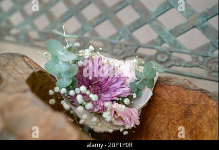 Le bouquet de fleurs à la main se compose de chrysanthème, de roses et de feuilles vertes sur un récipient en bois. Copier l'espace. Banque D'Images