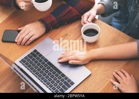 Vue de dessus image de trois jeunes asiatiques utilisant et regardant le même ordinateur portable pendant une réunion Banque D'Images