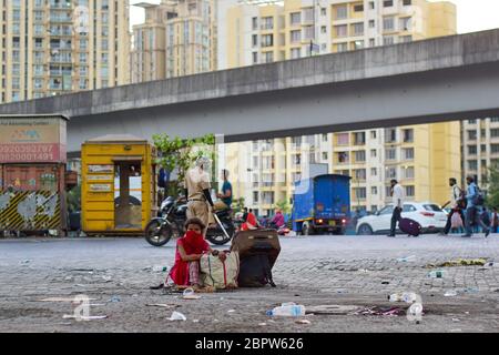 Mumbai, Inde. 19 mai 2020. Une femme est assise près de la National Highway en attendant le transport pour retourner à sa ville natale.les gens attendent que les bus gratuits fournis par le gouvernement pour retourner à leur ville natale à Mumbai. Ces bus vont déposer les migrants à la frontière de leurs États et de là ils doivent voyager par eux-mêmes. Crédit : SOPA Images Limited/Alamy Live News Banque D'Images