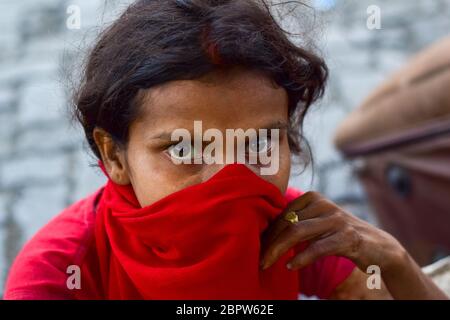 Mumbai, Inde. 19 mai 2020. Une femme est assise près de la National Highway en attendant le transport pour retourner à sa ville natale.les gens attendent que les bus gratuits fournis par le gouvernement pour retourner à leur ville natale à Mumbai. Ces bus vont déposer les migrants à la frontière de leurs États et de là ils doivent voyager par eux-mêmes. Crédit : SOPA Images Limited/Alamy Live News Banque D'Images