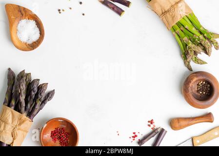 Fond végétal de deux petits pains d'asperges naturelles fraîchement cueillies et d'ingrédients pour cuisiner des plats maison à la lumière Banque D'Images