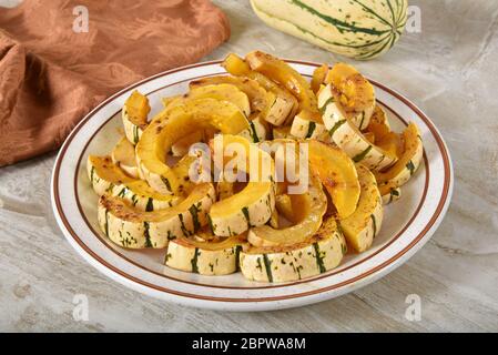 Tranches de courge delicata rôties dans un glaçage à la cannelle et au sucre brun Banque D'Images