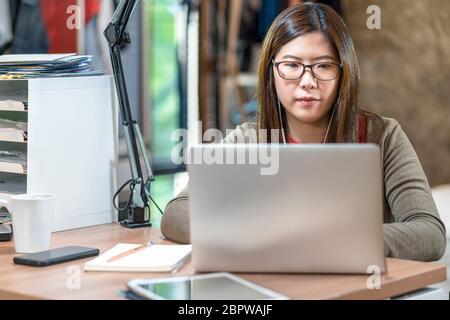 Femme d'affaires asiatique utilisant la technologie portable et travaillant à la maison dans la chambre, la vidéo conférence et l'éducation, startups et propriétaire d'affaires, style de vie oc Banque D'Images