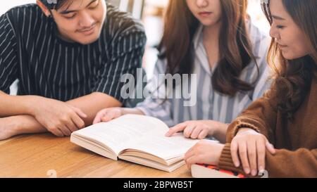 Groupe de jeunes personnes ont apprécié la lecture du même livre ensemble Banque D'Images