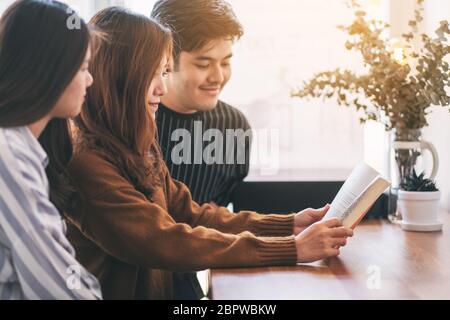 Groupe de jeunes personnes ont apprécié la lecture du même livre ensemble Banque D'Images