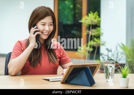 Femme d'affaires asiatique utilisant un téléphone mobile avec clavier et appelant pour travailler de la maison et le jardin en plein air, startups et propriétaire d'affaires, socia Banque D'Images