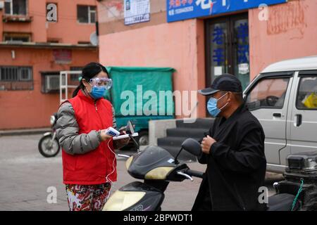 Jilin, province chinoise de Jilin. 19 mai 2020. Un travailleur communautaire vérifie la température corporelle d'un résident dans une collectivité de la zone de développement industriel de haute technologie de la ville de Jilin, dans la province de Jilin, au nord-est de la Chine, le 19 mai 2020. La province de Jilin, dans le nord-est de la Chine, a signalé quatre nouveaux cas confirmés de COVID-19 mardi, a déclaré la Commission nationale de la santé dans son rapport quotidien mercredi. Crédit: Yan Linyun/Xinhua/Alay Live News Banque D'Images