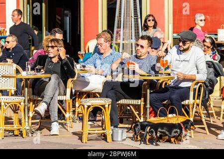 Les gens boivent un apéritif et se détendent dans un bar du cours Saleya à Nice. Nice, France, janvier 2020 Banque D'Images