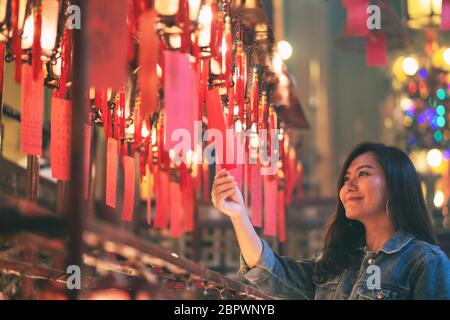 Une belle femme asiatique à déguster à lampes rouges et souhaits in Chinese Temple Banque D'Images