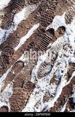 empreintes de pas sur un sentier sale couvert de neige après une chute de neige dans le parc de la ville par beau temps Banque D'Images