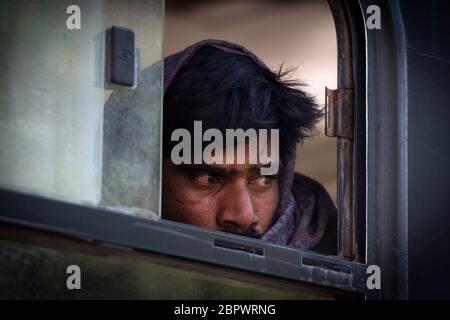 Un homme indien sans abri est assis dans un bus alors qu'il est expulsé avec d'autres sans-abri et des travailleurs migrants des rives de la rivière Yamuna où ils ont été squattés pendant leur confinement à New Delhi, en Inde, le mercredi 15 avril 2020. Photographe : Kuldeep Singh Rohilla Banque D'Images