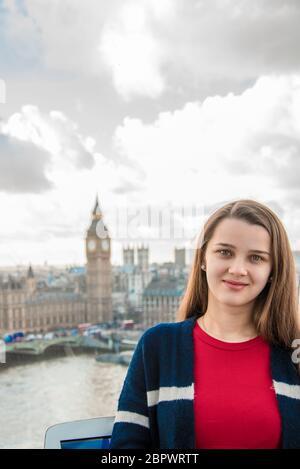 Jeune belle jolie fille looks tout en se tenant dans une cabine de roue de ferris à Londres. Jeune fille au London Eye. Banque D'Images