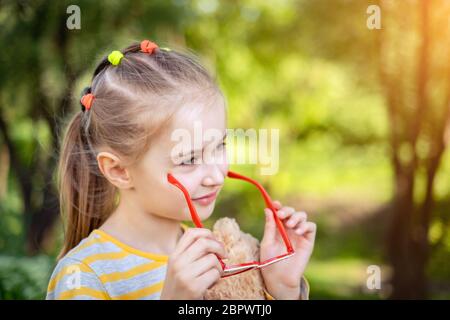 Petite fille souriante dans des lunettes de soleil fraîches Banque D'Images