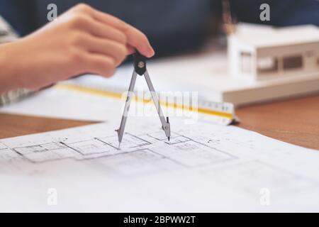 Un architecte à l'aide de compas pour tracer et mesurer le dessin d'atelier in office Banque D'Images