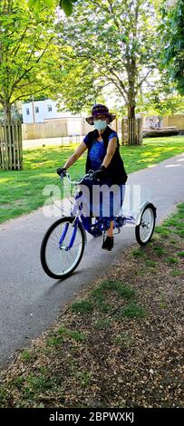 Une femme cycliste masquée à Bushy Park, au Royaume-Uni, pendant le couronnement du virus. Londres, Royaume-Uni. Banque D'Images