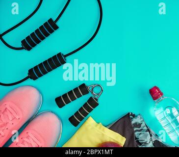 Chaussures de sport et autres articles textiles pour la remise en forme sur un fond vert, vue du dessus Banque D'Images