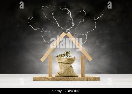 Concept de protection de l'environnement, maison en bois sur fond gris avec sac plein de pièces sous le toit et la foudre Banque D'Images