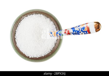 Vue de dessus une salière en céramique avec cuillère avec du sel de roche à grain fin isolé sur fond blanc Banque D'Images