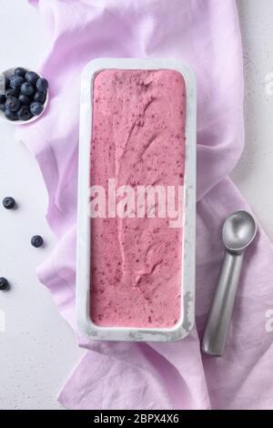 Glace aux myrtilles maison dans un contenant en métal sur fond blanc. Vue de dessus. Manger propre. Sans sucre. Banque D'Images