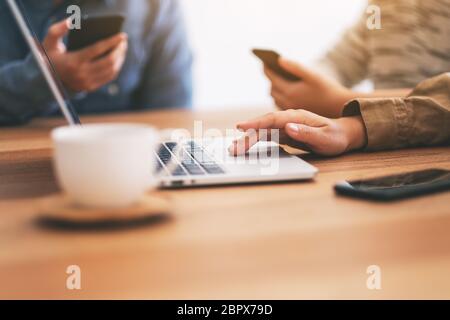 Libre de droit des personnes à l'aide de téléphone mobile et ordinateur portable sur une table en bois Banque D'Images